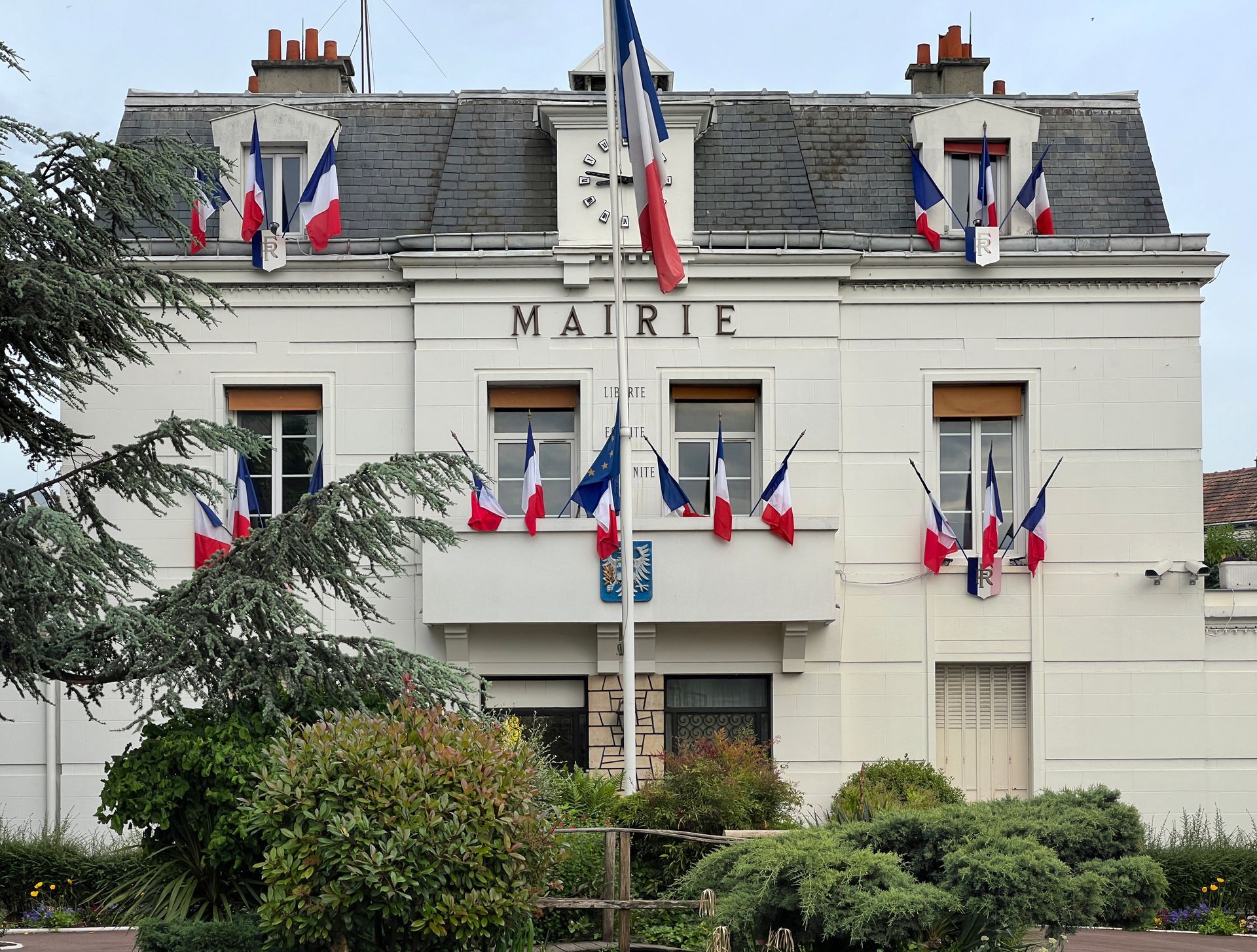 Un bâtiment avec de nombreux drapeaux français.