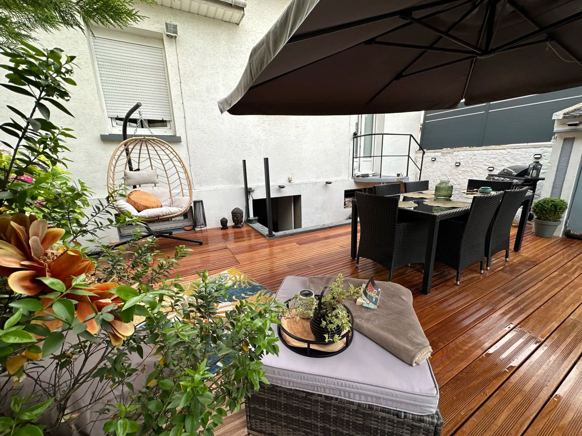 Une terrasse avec une table et des plantes.
