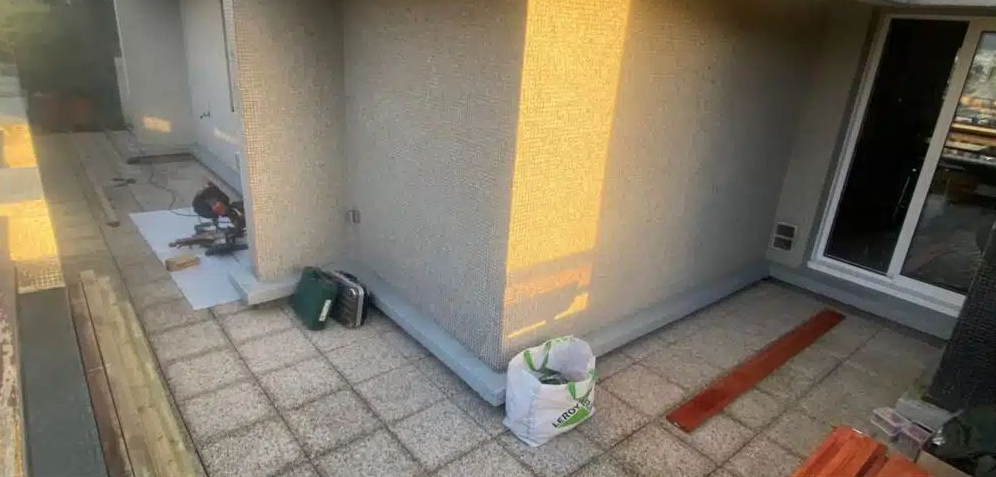 Une terrasse en dalles et un sac blanc.