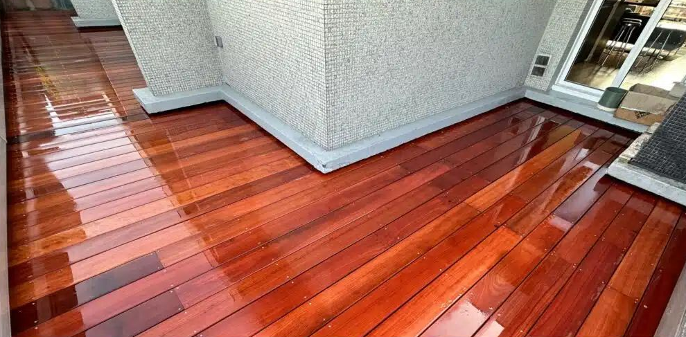 Une terrasse en bois très brillante et une fenêtre.