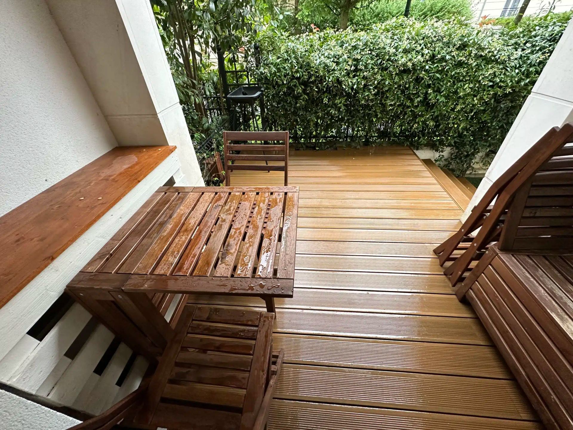 Une terrasse avec du mobilier en bois.