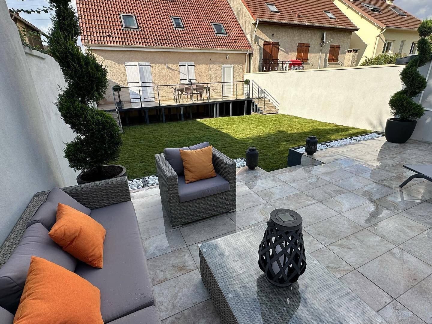 Une terrasse avec un fauteuil de jardin.