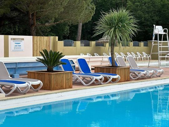 Des transats au bord d'une piscine.