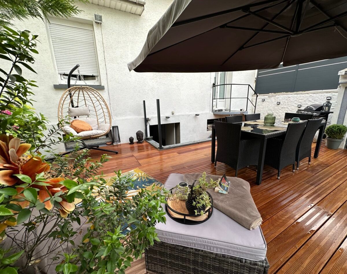 Une terrasse avec un parasol.