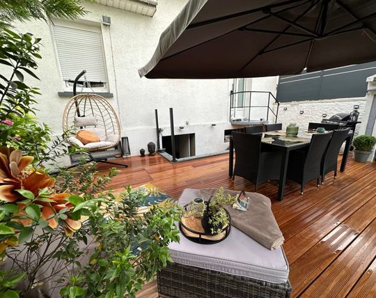 Une terrasse avec un parasol.