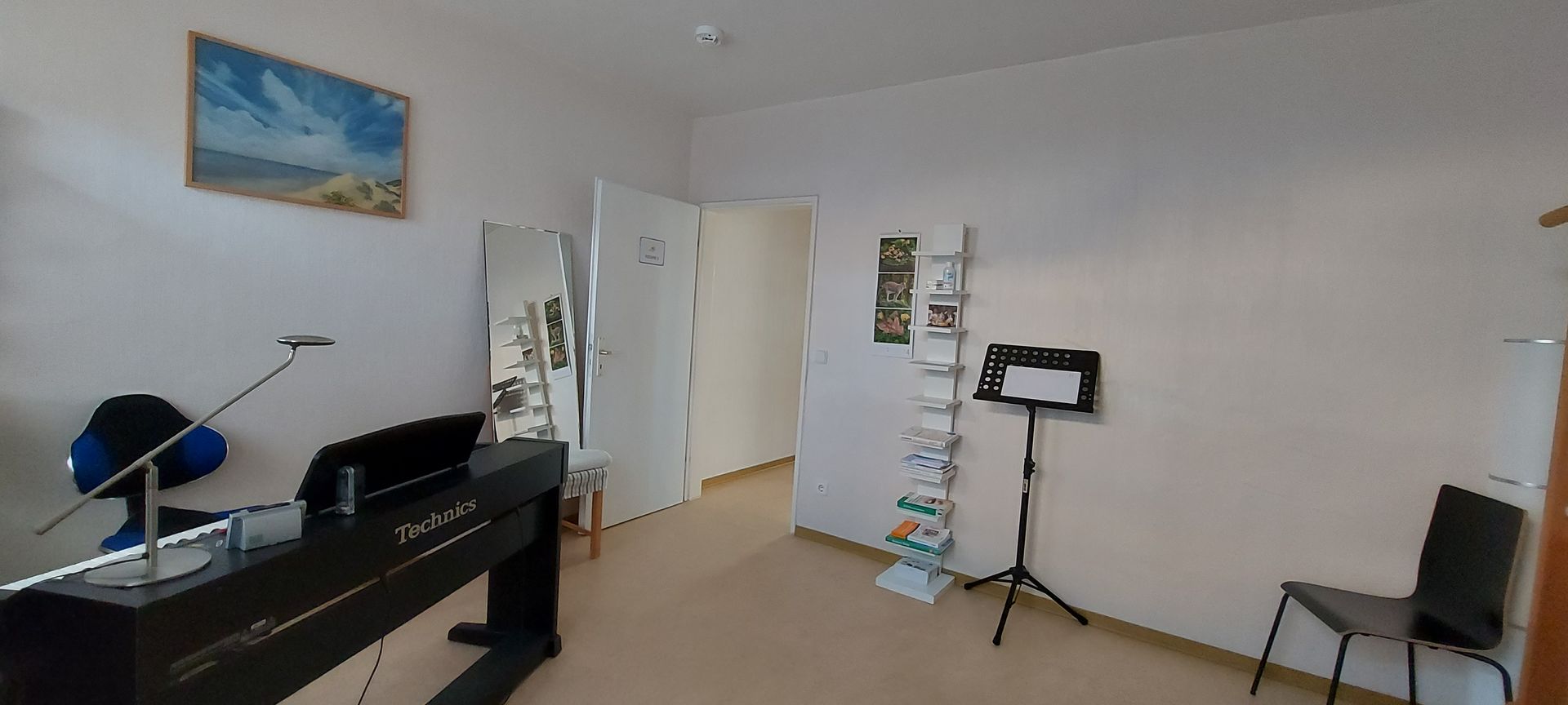 Ein Raum mit einem Klavier und einem Stuhl darin.