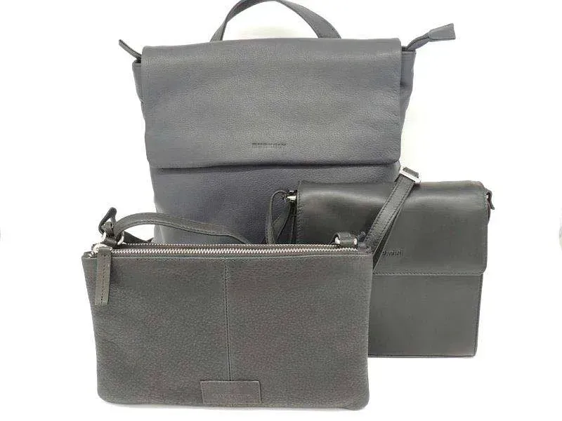 Drei graue Handtaschen mit Reißverschluss und ein Rucksack sind auf einem weißen Hintergrund angeordnet.