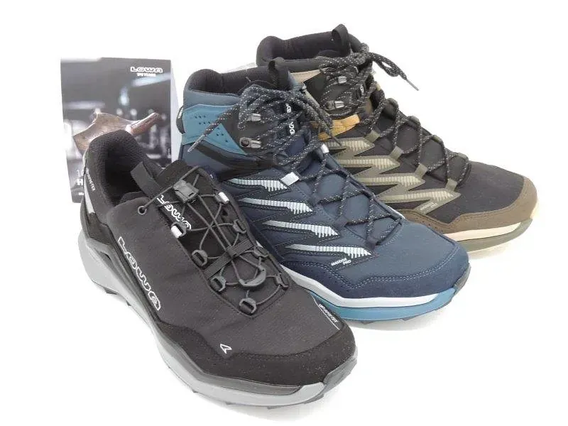 Drei Wanderschuhe in Schwarz, Blau und Grau, abgebildet neben einer Produktverpackung