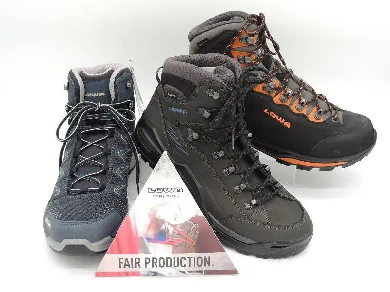 Drei Wanderschuhe mit einem Fair-Production-Etikett auf weißem Hintergrund