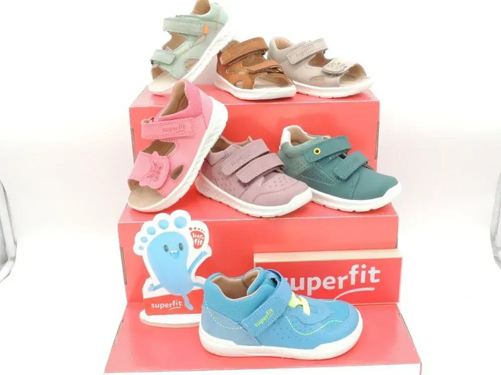 Bunte Kinderschuhe, ausgestellt auf einem roten Superfit-Ständer