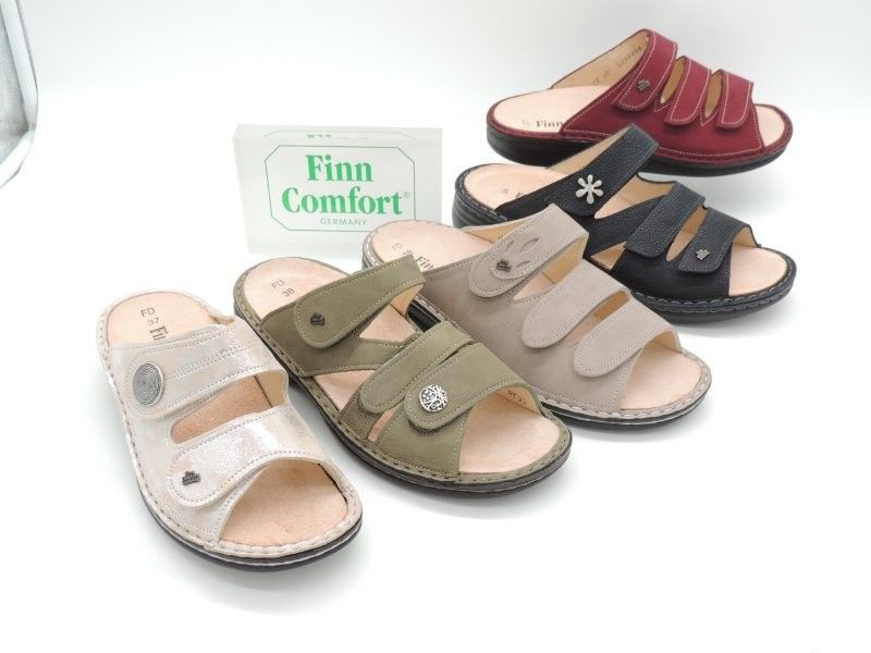 Verschiedene Finn Comfort Sandalen in unterschiedlichen Farben auf weißem Untergrund.