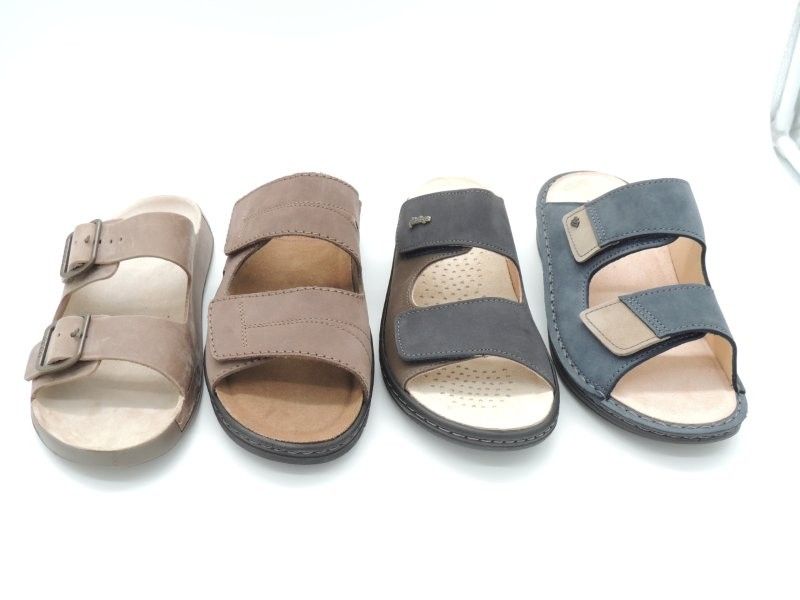 Vier Paar offene Sandalen in Beige, Hellbraun, Grau und Blaugrau auf weißem Hintergrund