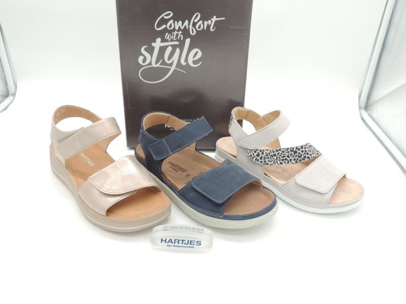 Drei Paar bequeme Sandalen in Beige, Marineblau und Weiß auf einem Display mit dem Schild „Komfort-Stil“.