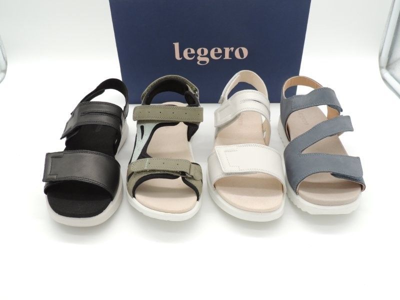 Vier Legero-Sandalen in Schwarz, Olivgrün, Weiß und Grau aufgereiht auf einem Ausstellungsständer