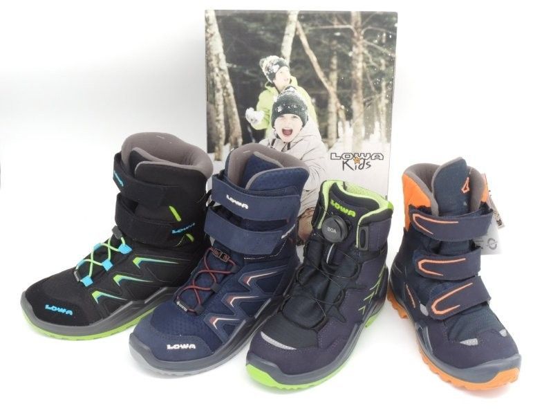 Vier Winterstiefel in Schwarz, Marineblau und Grau mit Neonakzenten sind im Freien in einer Reihe ausgestellt.