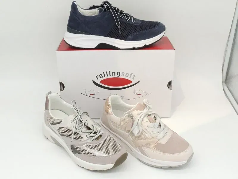 Drei Sportschuhe in Marineblau, Weiß und Beige, präsentiert auf einem Rollingsoft-Karton.