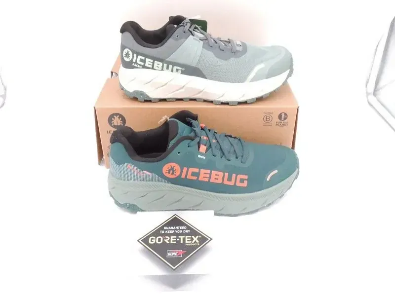 Zwei ICEBUG-Trailrunningschuhe, grau und türkis, auf einem Karton mit Gore-Tex-Etikett.