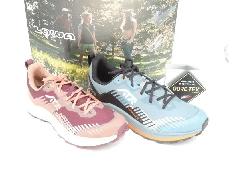 Zwei Trailrunning-Schuhe, ein pinkfarbener und ein blauer, jeweils mit GORE-TEX-Etikett.