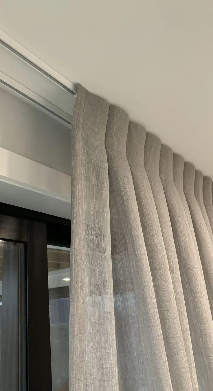 Un primer plano de un par de cortinas colgadas en una ventana.