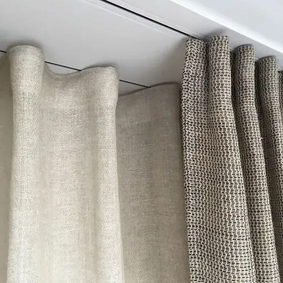 Un primer plano de un par de cortinas colgando del techo.