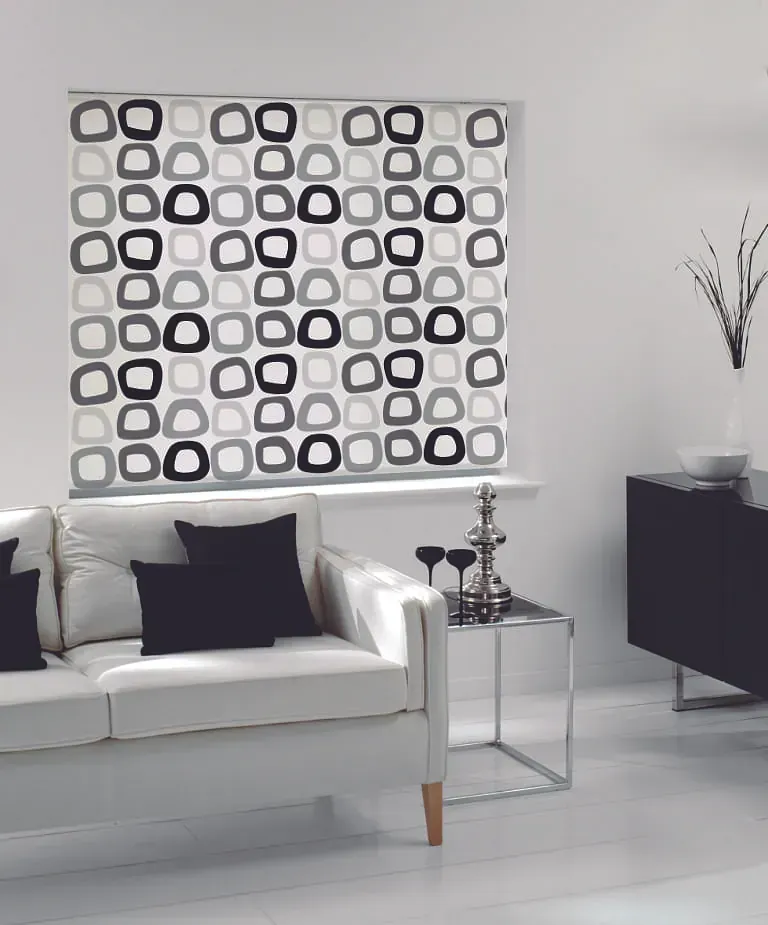 Una sala de estar con un sofá y una ventana con un estampado.