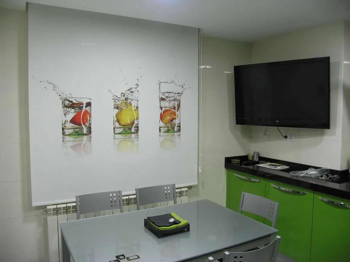 Una cocina con mesa y sillas y un televisor de pantalla plana.