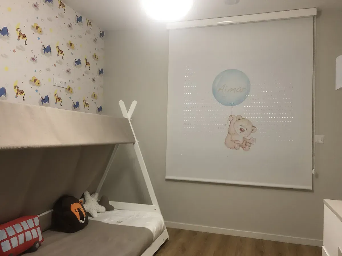 Un dormitorio con un osito de peluche sosteniendo un globo en la pared.