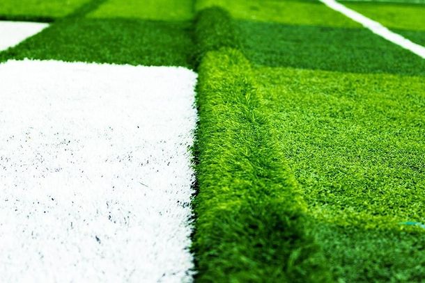 Un primer plano de un campo de fútbol con una línea blanca en el medio.