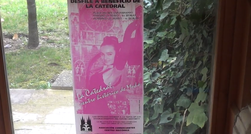 Cartel rosa: Evento “La Catedral”, con una mujer como protagonista, expuesto en una ventana.