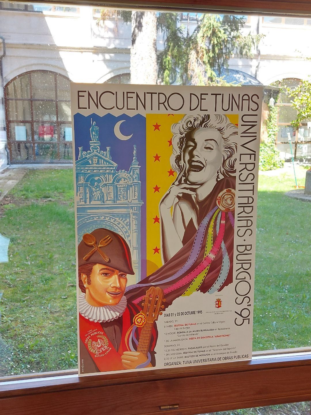 Cartel de un festival de música universitario en Burgos, 1995. Presenta a una mujer con una banda colorida y a un hombre con un traje histórico.