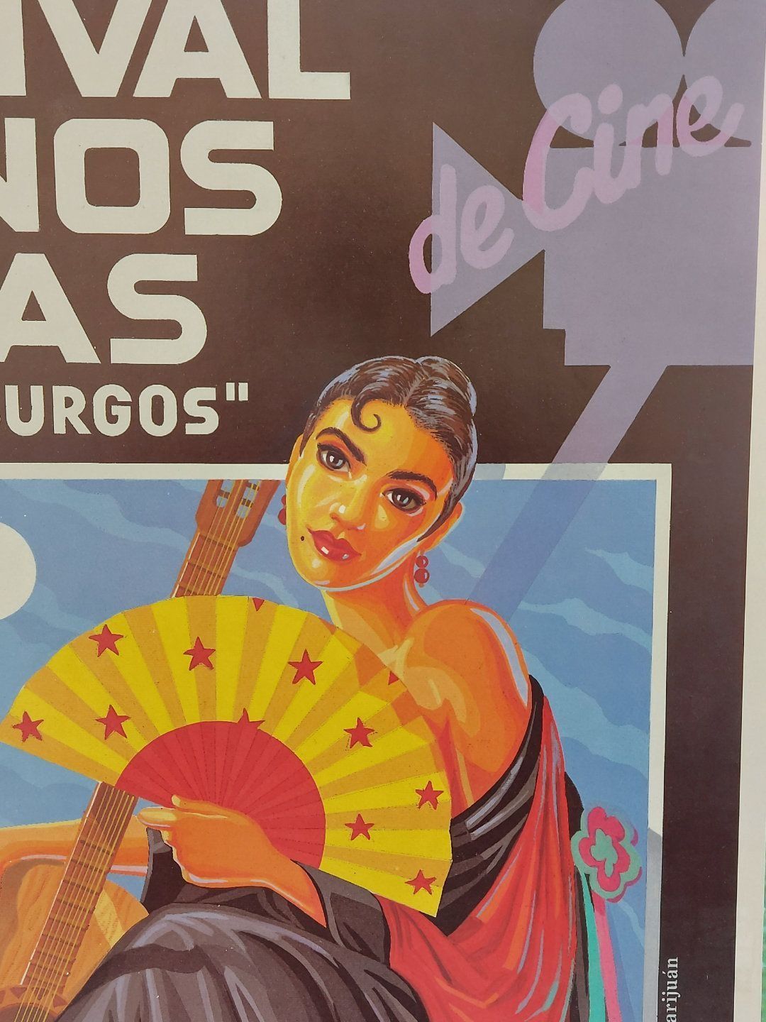 Mujer sosteniendo un abanico y una guitarra, parte de un cartel de un festival de cine.