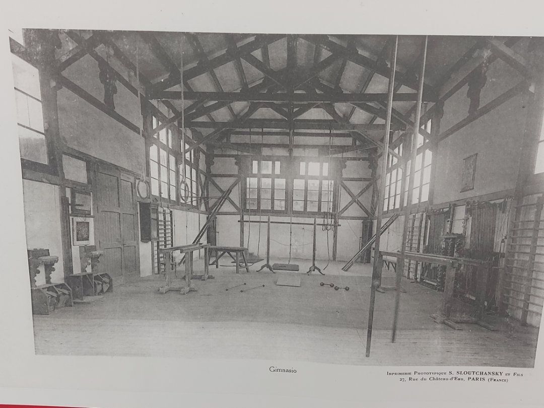 Interior de un gran salón vacío con marco de madera y ventanas.