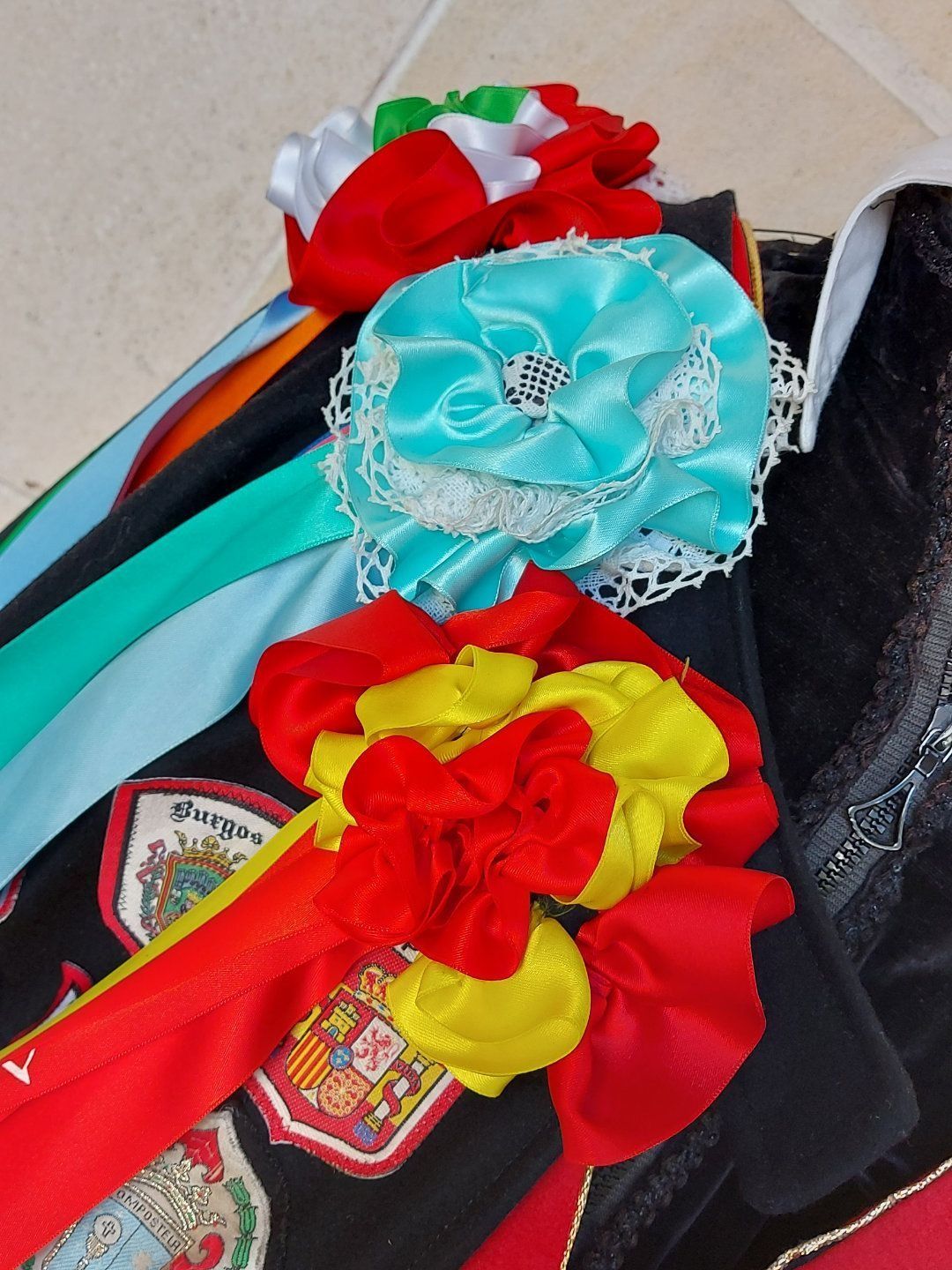 Primer plano de rosetas de cinta de raso de colores, posiblemente para decoración o ceremonia.