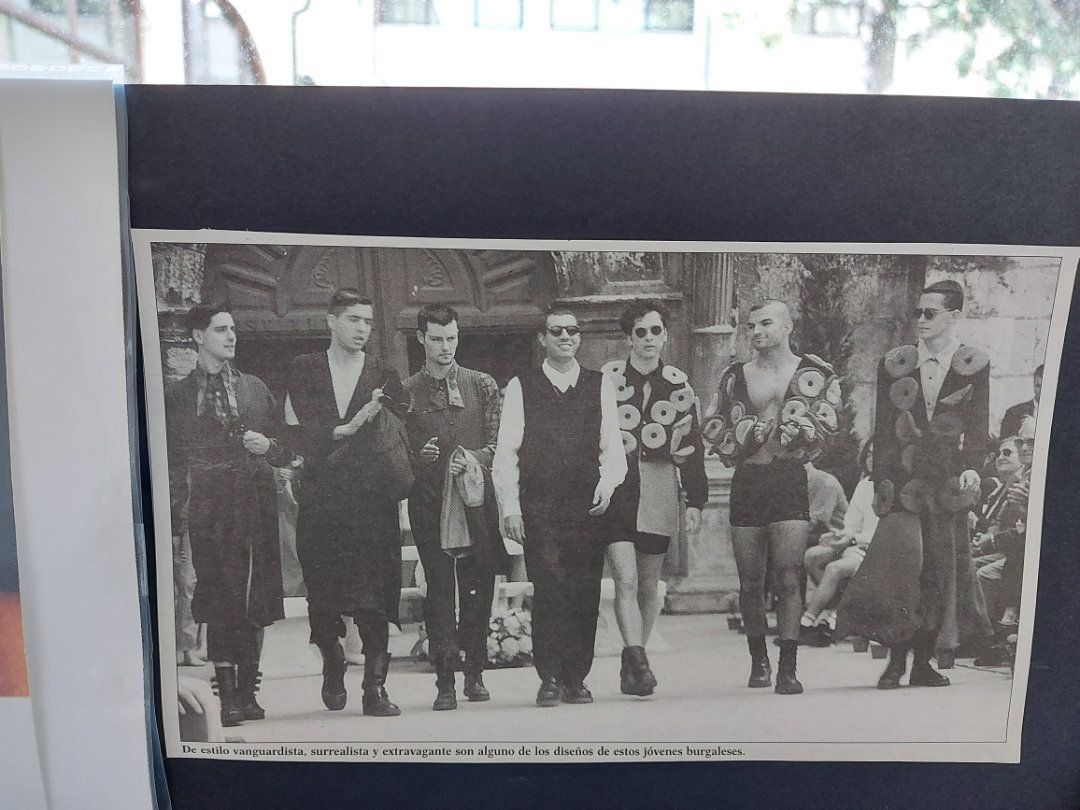 Grupo de personas con atuendos diversos, algunos vanguardistas, caminando. Fotografía en blanco y negro.