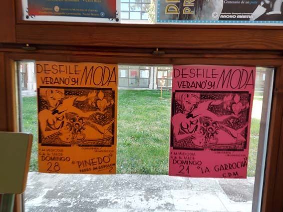 Dos carteles anunciando un desfile de moda de verano. Uno naranja y otro rosa, ambos con ilustraciones y texto.