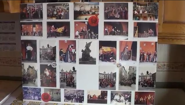 Exhibición de fotografías de eventos en un tablero, con personas, acentos rojos y configuraciones ornamentadas.