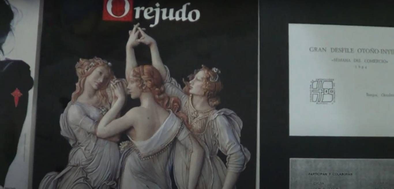 Un cartel con la escultura de tres mujeres pelirrojas. El texto 