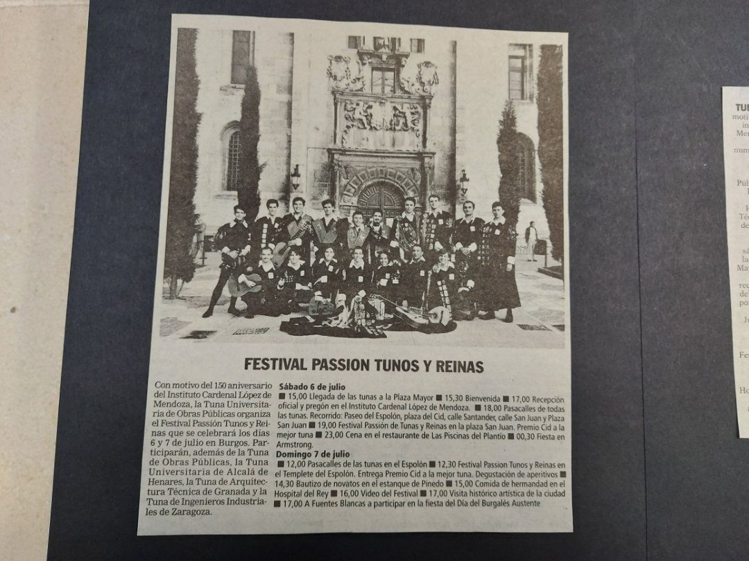 Fotografía grupal en blanco y negro de personas frente a un edificio, el texto debajo dice 