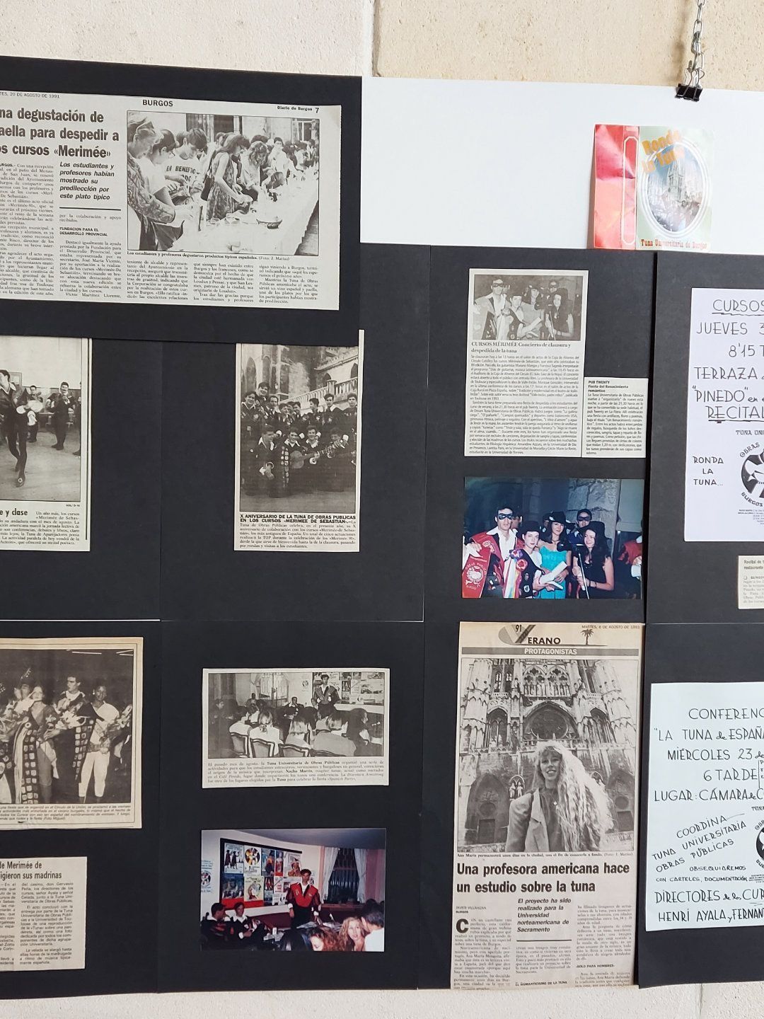 Recortes de periódico y fotos en blanco y negro montados sobre una pizarra. Los temas incluyen personas, eventos y artículos.