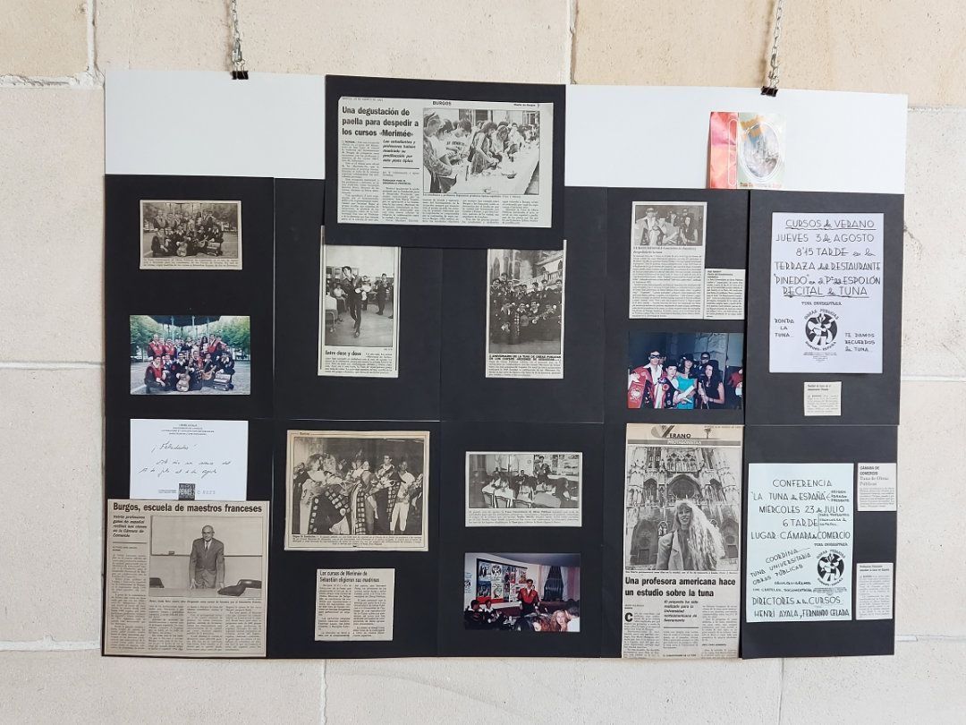 Un tablero con recortes de periódicos y fotografías sobre eventos históricos, colocado contra una pared blanca.