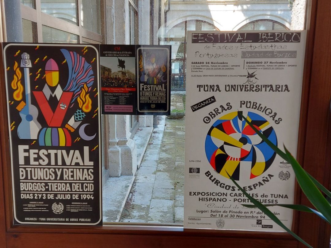 Carteles en un escaparate, anunciando festivales y eventos universitarios en España, Burgos. Diseños coloridos, estilo vintage.