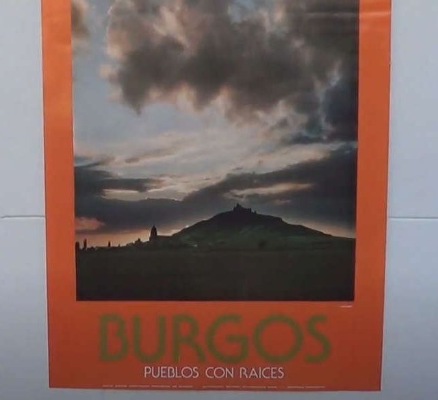 Un cartel con una montaña bajo un cielo nublado. El texto dice 