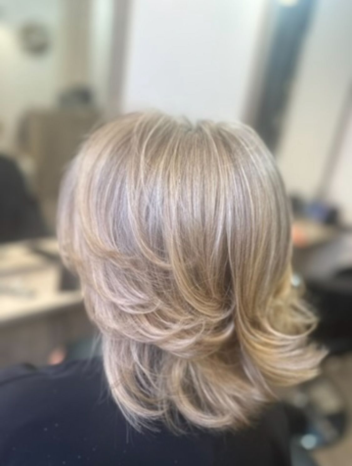 Cheveux avec un balayage blond avec des reflets froids et grisonnants 