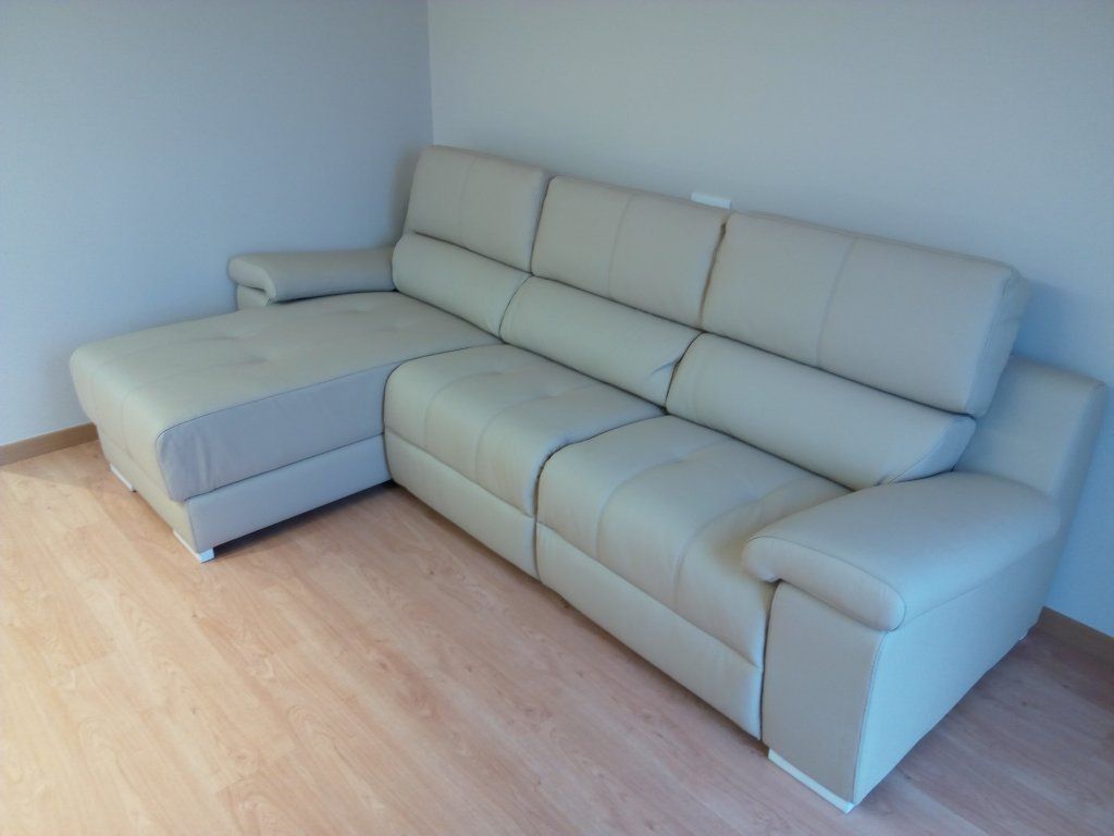 Sofá modular gris en una habitación vacía con suelo de madera clara.