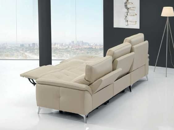 Sofá seccional reclinable color beige en una sala de estar moderna con ventanas con vista a la ciudad.