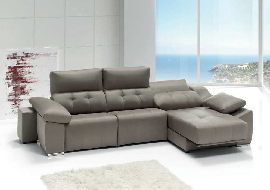 Sofá modular gris en una habitación moderna y luminosa con una gran ventana con vistas al mar.
