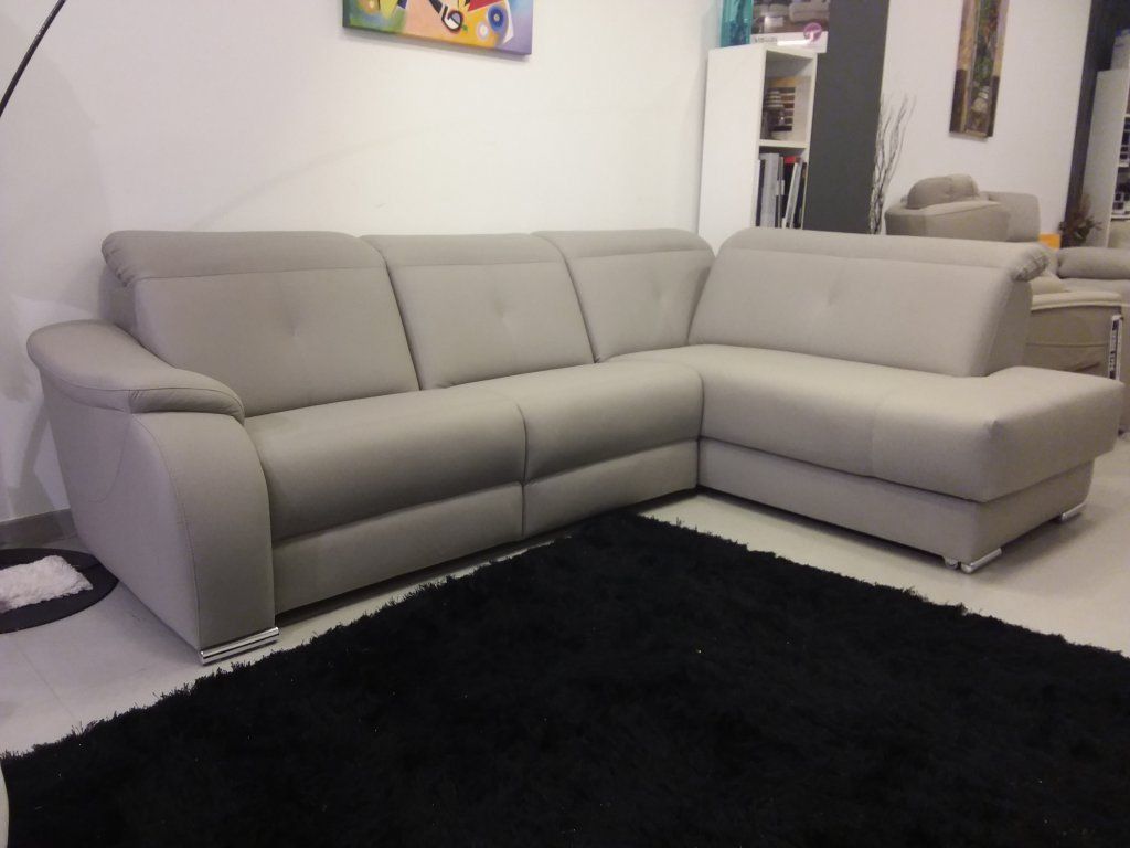 Sofá modular beige en una sala de estar moderna con una alfombra negra sobre un suelo claro.