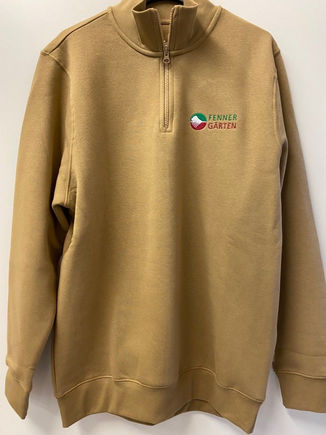 Ein hellbraunes Sweatshirt mit der Aufschrift „Terrasse“ darauf