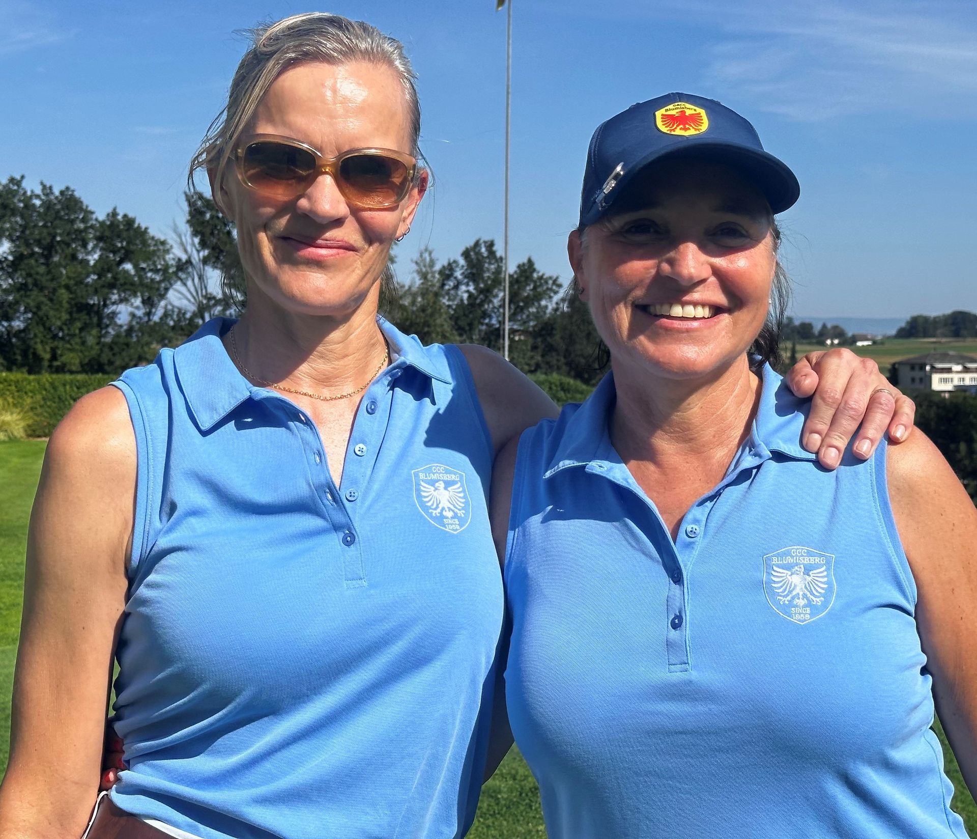 Zwei Frauen in blauen Hemden posieren für ein Foto
