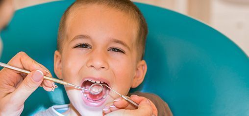 Un niño pequeño está siendo examinado por un dentista.